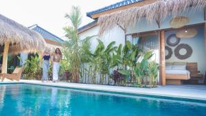 two women standing next to a house with a swimming pool at petra bianca uluwatu in Uluwatu +45 photos
