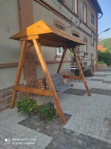 una mesa de picnic de madera frente a un edificio en Dawna Mleczarnia Apartament LOFT, en Nowa Ruda