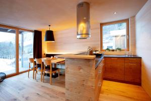 a kitchen with a wooden counter and a table with chairs at n Apartments Hotel in Schoppernau