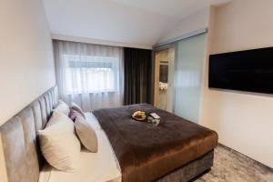 a hotel room with a large bed and a flat screen tv at Hotel Pogoria Residence in Dąbrowa Górnicza