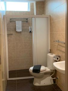 a bathroom with a toilet and a sink and a shower at Simfoni Resort Langkawi in Kuah