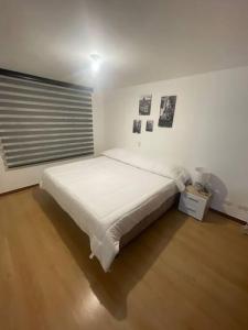 een slaapkamer met een groot wit bed in een kamer bij Apartamento en el poblado con vista ala ciudad in Medellín