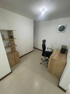 een kantoor met een bureau en een stoel in een kamer bij Apartamento en el poblado con vista ala ciudad in Medellín