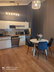 a kitchen with a table and chairs in a room at Dawna Mleczarnia Apartament FAMILIJNY in Nowa Ruda
