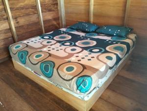 un letto con coperta e cuscini sopra di Palambak Paradise Resort Pulau Banyak a Pulau Palambakbesar