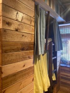 a room with a wooden wall with curtains at Surfer's Cafe& Hostel in Chatan