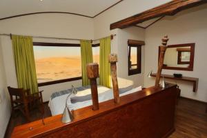 a bedroom with a bed with a view of the desert at Desert Breeze Lodge in Swakopmund