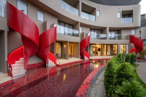 uma vista externa de um edifício com colunas vermelhas em Metadee Concept Hotel em Praia de Kata