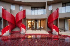 a building with red sculptures in front of it at Metadee Concept Hotel in Kata Beach