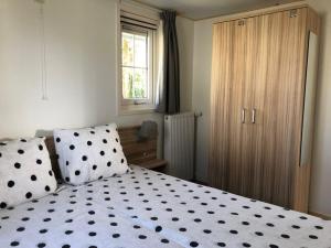 - une chambre dotée d'un lit avec des points de polka noirs et blancs dans l'établissement Vakantiehuis voor 6 personen, à Opheusden