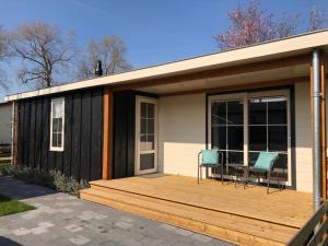 een huis met een terras met twee stoelen erop bij Vakantiehuis voor 6 personen in Opheusden