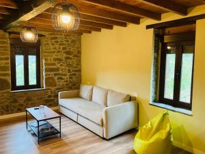 sala de estar con sofá y mesa en La So Casa -En el corazón de Asturias, en Armiello