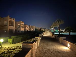a street at night with buildings and trees and lights at Peaceful Beach in Ain Sokhna