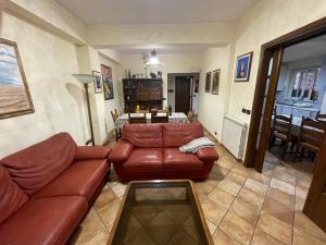 a living room with a leather couch and a table at La casa nel villaggio dei pescatori in Spadafora