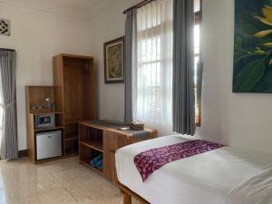 um quarto com uma cama e uma janela em Narasoma Homestay & Retreat em Ubud