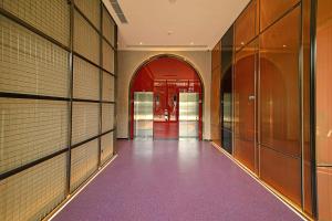 een lege hal met paarse vloeren en glazen deuren bij Greenery Inn in Macau