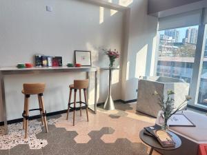 a living room with two stools and a counter with a window at Greenery Inn in Macau