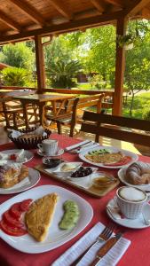 Kompleksi Turistik Leonardo في شينجين: طاولة مع أطباق من الطعام على قماش الطاولة الحمراء