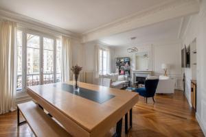 a kitchen and living room with a wooden table and chairs at Jemmapes - Wonderful apartment near République place in Paris