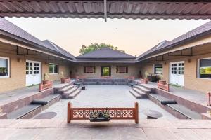 a courtyard with a bench in front of a building at Vanaashrya Resort and Spa Sariska in Tehla