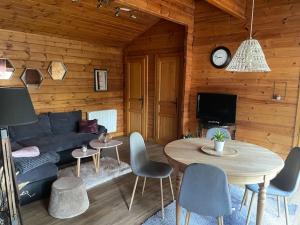 a living room with a couch and a table at Chalet cosy, cadre apaisant in Saint-Léonard