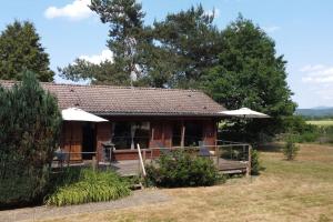 a log cabin in a field with trees at Chalet cosy, cadre apaisant in Saint-Léonard