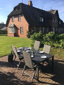 ein schwarzer Tisch mit Stühlen und ein Haus im Hintergrund in der Unterkunft Ferienwohnung Britta in Wyk auf Föhr