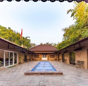 a swimming pool in the courtyard of a building at Vanaashrya Resort and Spa Sariska in Tehla