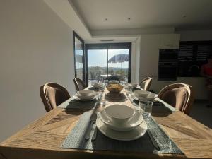 a wooden table with plates and bowls on top of it at Villa sun dream in Septèmes-les-Vallons