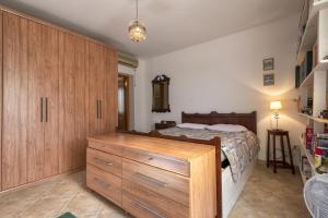 1 dormitorio con 1 cama y armario de madera en Casa Rina, en Sassari