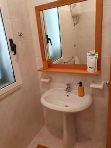 a bathroom with a sink and a mirror at Casa vacanze Elisio in Torre dell'Orso +7 photos