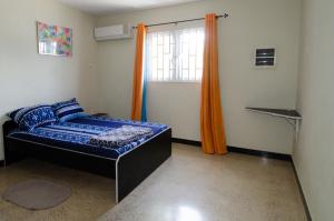 a bedroom with a blue bed and a window at Blue Apartments in Willemstad