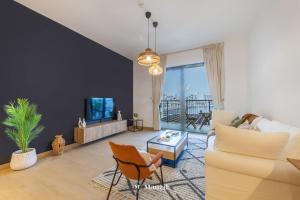 Una sala de estar con un sofá y un televisor. en Manzil - 1BR Home in Port de la Mer w Lake Access, en Dubái
