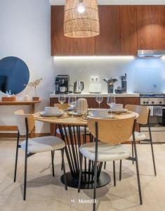 cocina con mesa de madera con sillas y comedor en Manzil - 1BR Home in Port de la Mer w Lake Access, en Dubái