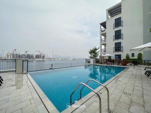 una piscina en la azotea de un edificio en Manzil - 1BR Home in Port de la Mer w Lake Access, en Dubái