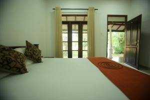 una camera da letto con un letto grande e una finestra di Nature Lodge a Sigiriya