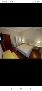 a bedroom with a large white bed and two tables at La Terrazza Quisisana Sorrento Coast in Castellammare di Stabia
