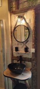W łazience znajduje się czarna umywalka i lustro. w obiekcie La cabane des amoureux w mieście Sarlat-la-Canéda