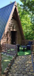 una cabaña de madera con un banco delante en La cabane des amoureux, en Sarlat-la-Canéda