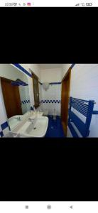 ein Badezimmer mit einem weißen Waschbecken und einem blauen Stuhl in der Unterkunft La Terrazza Quisisana Sorrento Coast in Castellammare di Stabia