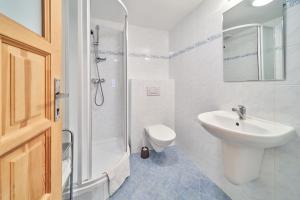 a white bathroom with a sink and a shower at Penzion Koula in Pec pod Sněžkou