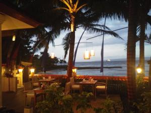 a restaurant with a view of the beach at night at Nusa Indah Candidasa in Candidasa