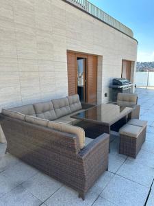 a patio with couches and a table and a grill at Luxury PENTHOUSE at the Historical Centre with free parking in Bratislava