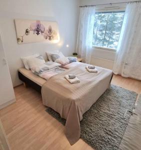 um quarto com uma cama grande com duas toalhas em Tilava kolmio upealla järvinäköalalla 3h+k em Uusikaupunki