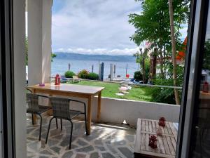 stół i krzesła na balkonie z widokiem na ocean w obiekcie Flora's Beach House Your House On The Beach w mieście Amarynthos