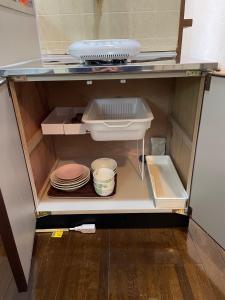 an open refrigerator with plates and dishes in it at Chambord Kyomachi 205 - Vacation STAY 69095v in Kumamoto
