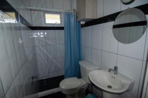 a bathroom with a toilet and a sink and a mirror at Blue Apartments in Willemstad