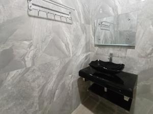 baño con lavabo negro y espejo en RedDoorz @ Green Homestay Syariah Baubau, en Bau-Bau