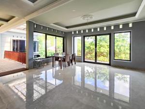 uma sala de estar vazia com uma mesa e janelas de vidro em RedDoorz @ Green Homestay Syariah Baubau em Baubau