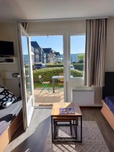 a living room with a bed and a sliding glass door at Appartement 4 personnes Arzon, entre plage et Port Crouesty in Arzon